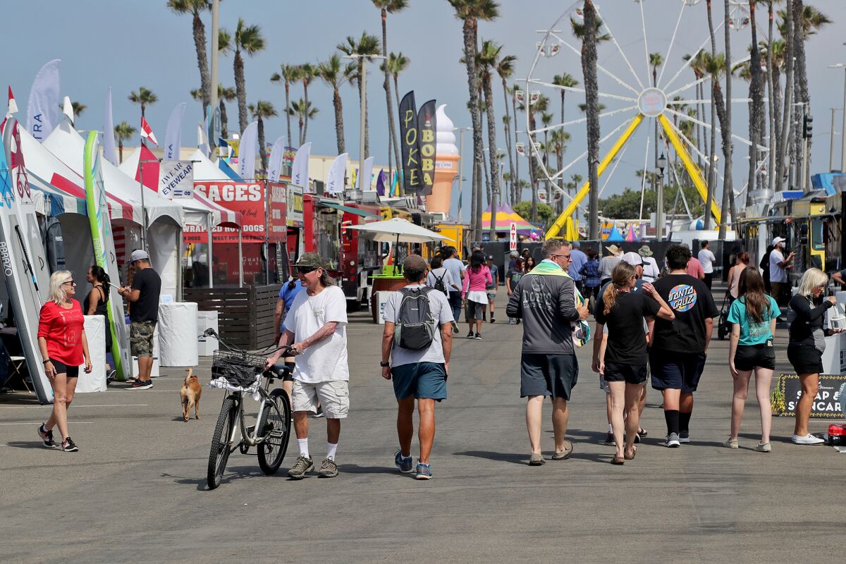 Visitors stroll through the food area at the Pier Plaza Fourth of July Festival in Huntington Beach on Friday.