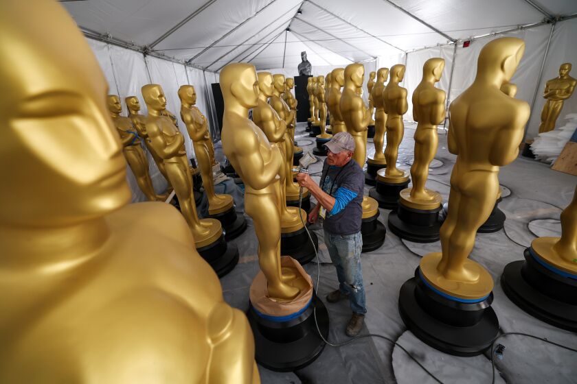 Los Angeles, CA, Thursday, March 9, 2023 - Scenic artist Michael Thomas touches up Oscar statues as work continues on Hollywood Blvd. in preparation for the 95th Academy Awards. (Robert Gauthier/Los Angeles Times)