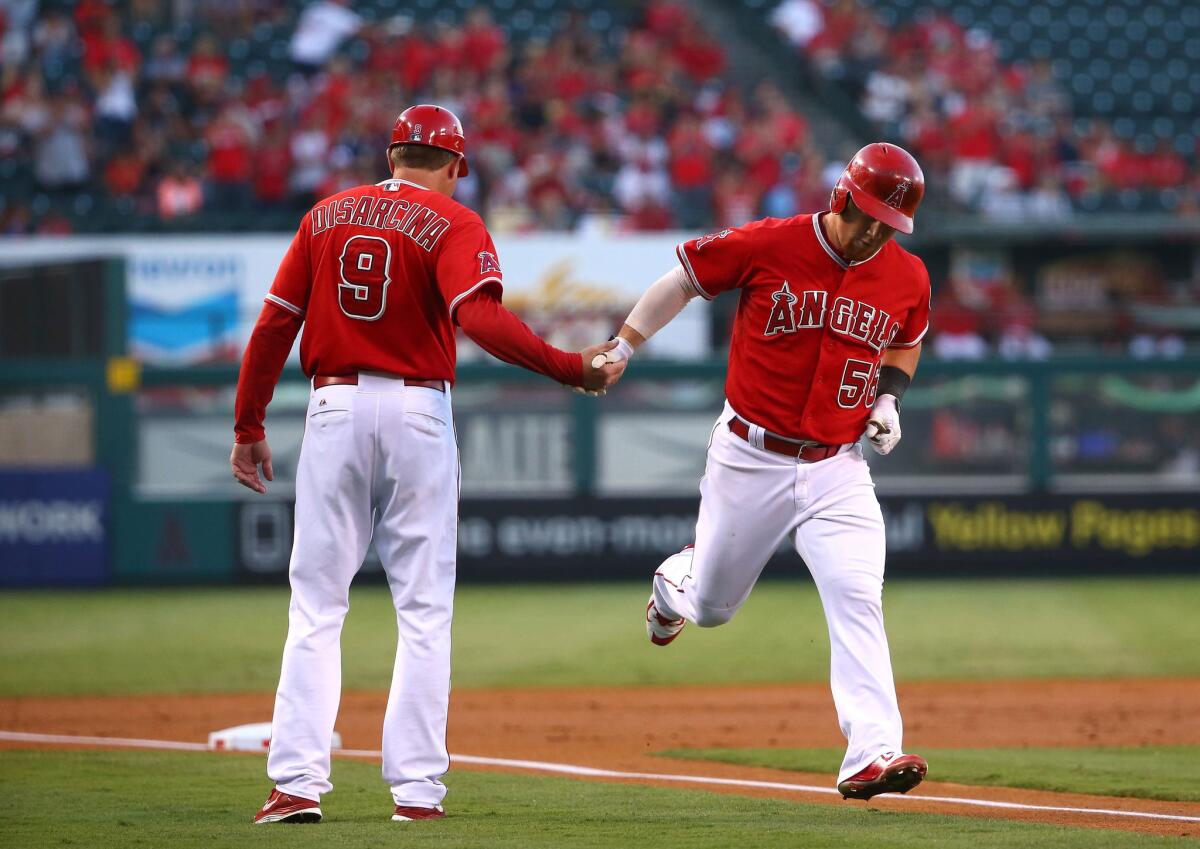 Angels outfielder Kole Calhoun is congratulated by third base coach Gary DiSarcina after hitting a two-run home run against the White Sox.