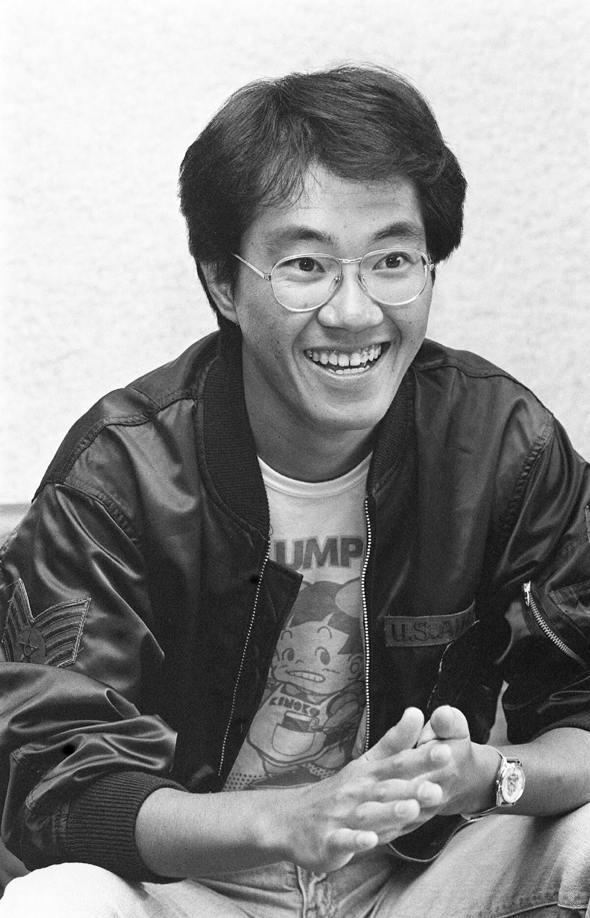 A smiling man in a black and white photo.