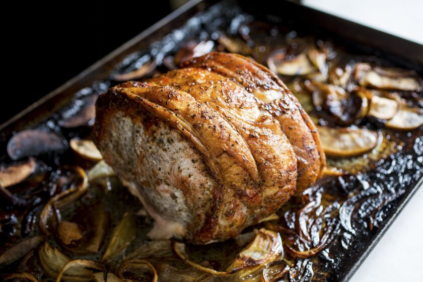 Pork loin on a sheet pan with apples and onions.
