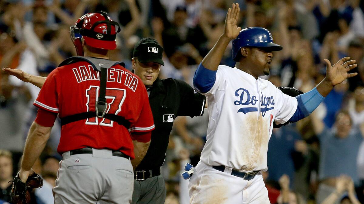 Dodgers third baseman Juan Uribe, right, celebrates next to Angels catcher Chris Iannetta after scoring on a walk-off error in the ninth inning of the team's 5-4 win Tuesday at Dodger Stadium.