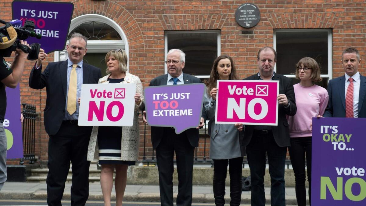 Activists from the "Love Both, Vote No" campaign, including politician Mattie McGrath, third from left, hold placards urging people to vote "no" in the referendum to repeal the 8th Amendment of the Irish Constitution.