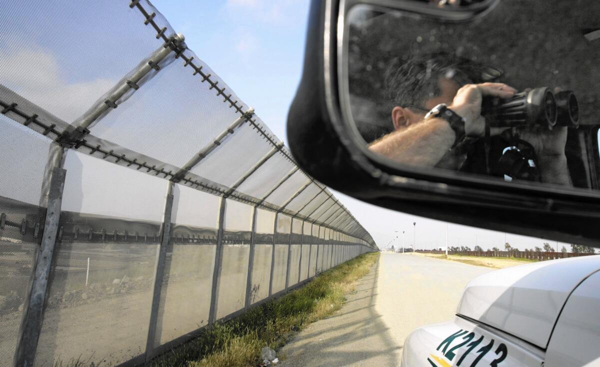 A border agent keeps watch on the Otay Mesa area. Non-citizens who cross on foot through Otay Mesa will be scanned in an effort to track non-immigrant visa holders who remain in the U.S. after permits expire.