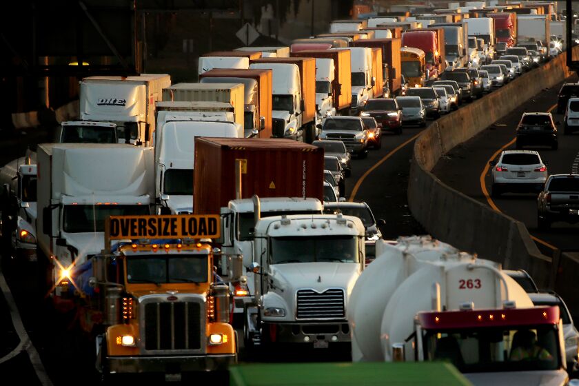 LONG BEACH, CALIF. - DEC. 2, 2021. Truck and car traffic jams the Long BBeach Freeway as cargo moves out of the ports of Long Beach and Los Angeles on Wednesday, Dec. 1, 2021. Port workers are trying to clear a supply chain backlog ahead of the yearend holidays. The activity has resulted in spikes of carbon emmissions in the surrounding communities of San Pedro, Wilmington and Long Beach. (Luis Sinco / Los Angeles Times)
