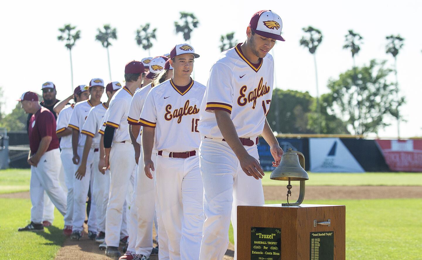 Estancia High's Justin Wood rings the Paul Troxel trophy following a 3-2 win over rival Costa Mesa in an Orange Coast League game at Estancia on Wednesday.