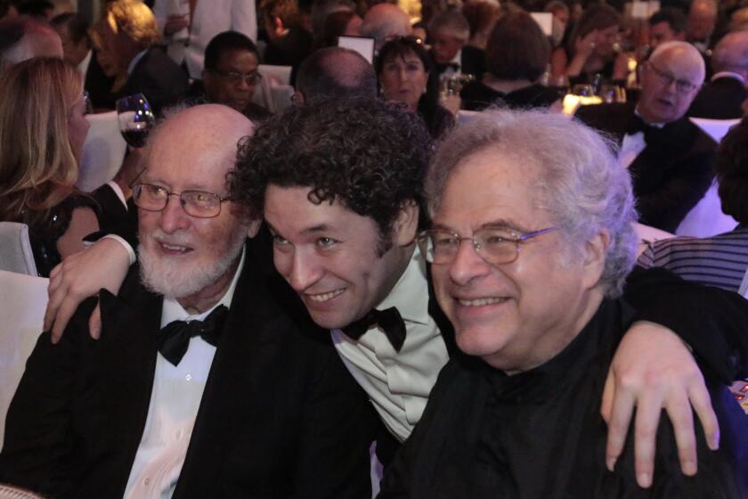 Gustavo Dudamel, center, poses for a picture with composer John Williams, left, and violinist Itzhak Perlman at the gala dinner after the LA Phil's season opening concert at Walt Disney Concert Hall.