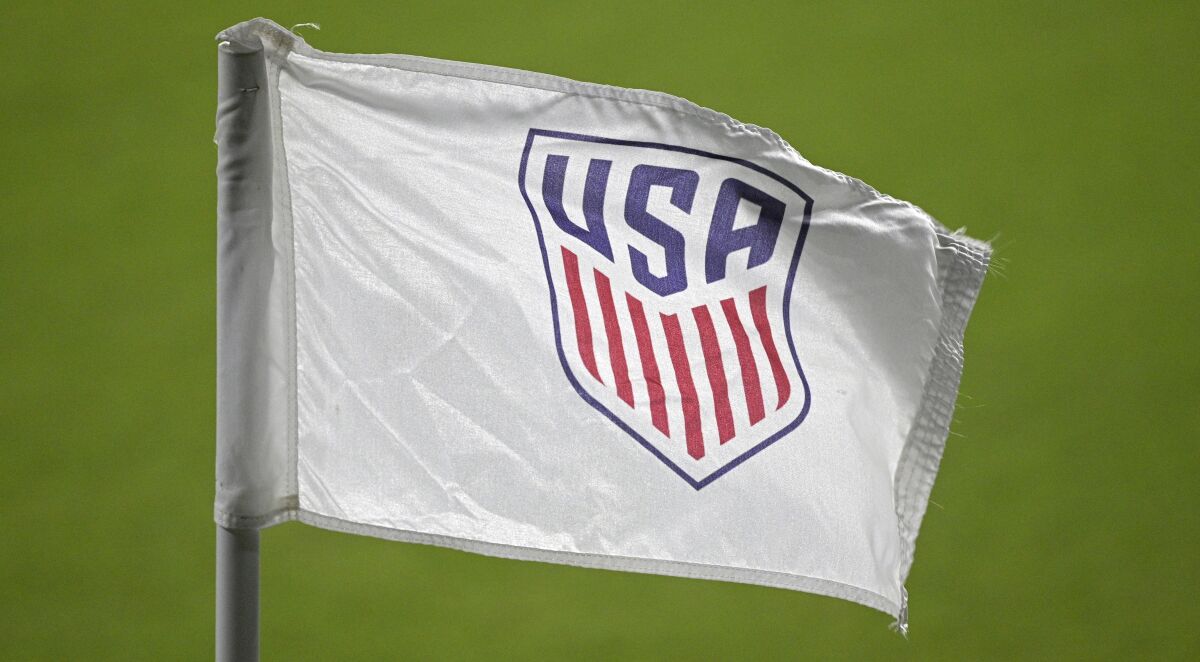 The United States Soccer Federation logo is viewed on a corner flag on the pitch, Sunday, Jan. 31, 2021, in Orlando, Fla. The U.S. Soccer Federation and the union for its women's national team agreed to a three-month extension of their labor contract through March, a move announced on the same day players filed a brief asking a federal appeals court to reinstate their equal pay claim. (AP Photo/Phelan M. Ebenhack)