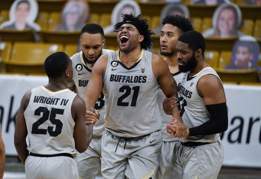 Colorado forward Evan Battey (21) is helped up by, from left, guard McKinley Wright IV, forward Dallas Walton, guard D'Shawn Schwartz and forward Jeriah Horne during the second half of the team's NCAA college basketball game against Arizona on Saturday, Feb. 6, 2021, in Boulder, Colo. Colorado won 82-79. (AP Photo/David Zalubowski)