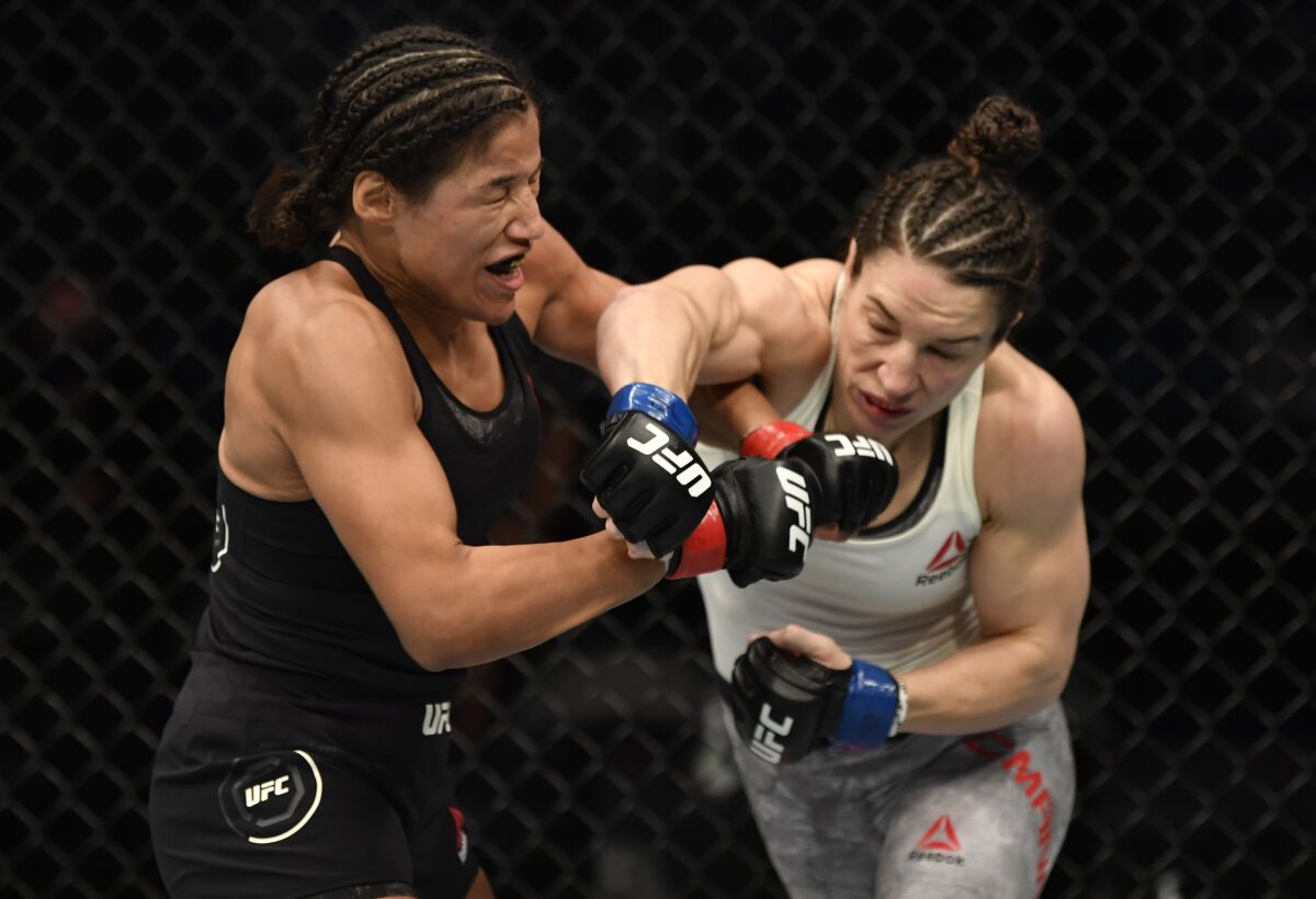 Sara McMann punches Julianna Pena during their bantamweight fight at UFC 257 on Saturday.
