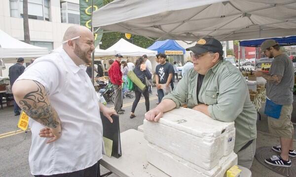 David West, right, sells wild porcini and morel mushrooms gathered from the mountains near the California- Oregon border, at the Santa Monica Saturday farmers market.