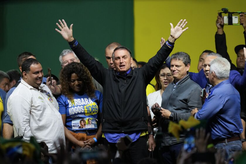 Brazilian President Jair Bolsonaro, who is running for a second term, waves to supporters during a campaign rally in Santos, Brazil, Wednesday, Sept. 28, 2022. Brazil's general elections are scheduled for Oct. 2. A former army captain, Bolsonaro campaigned in 2018 on an anti-corruption platform while defending a show-no-mercy approach to crimefighting, traditional family values and national pride. His 2018 slogan — “Brazil above all, God above everyone” — is back this year. (AP Photo/Andre Penner)