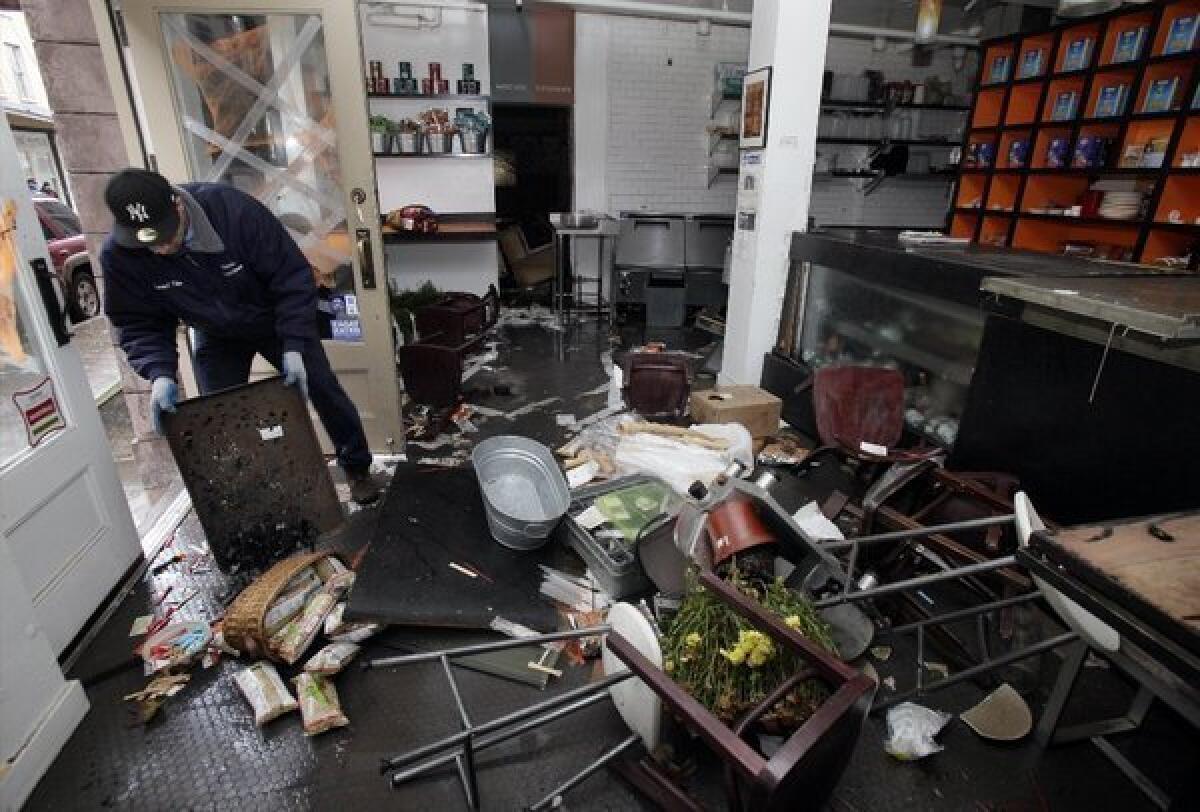 A man cleans up his store in New York's South Street Seaport after Superstorm Sandy.