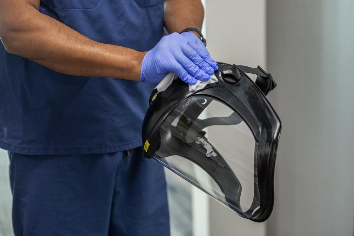 A doctor sanitizes his PPE after tending to a sick patient 