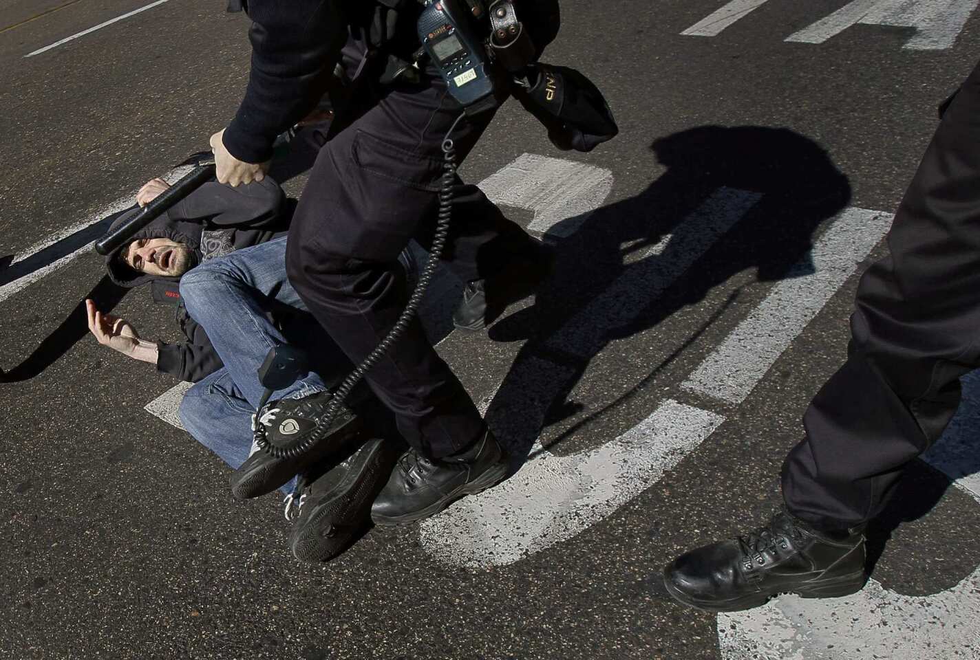 A protester is grabbed by police in Madrid.