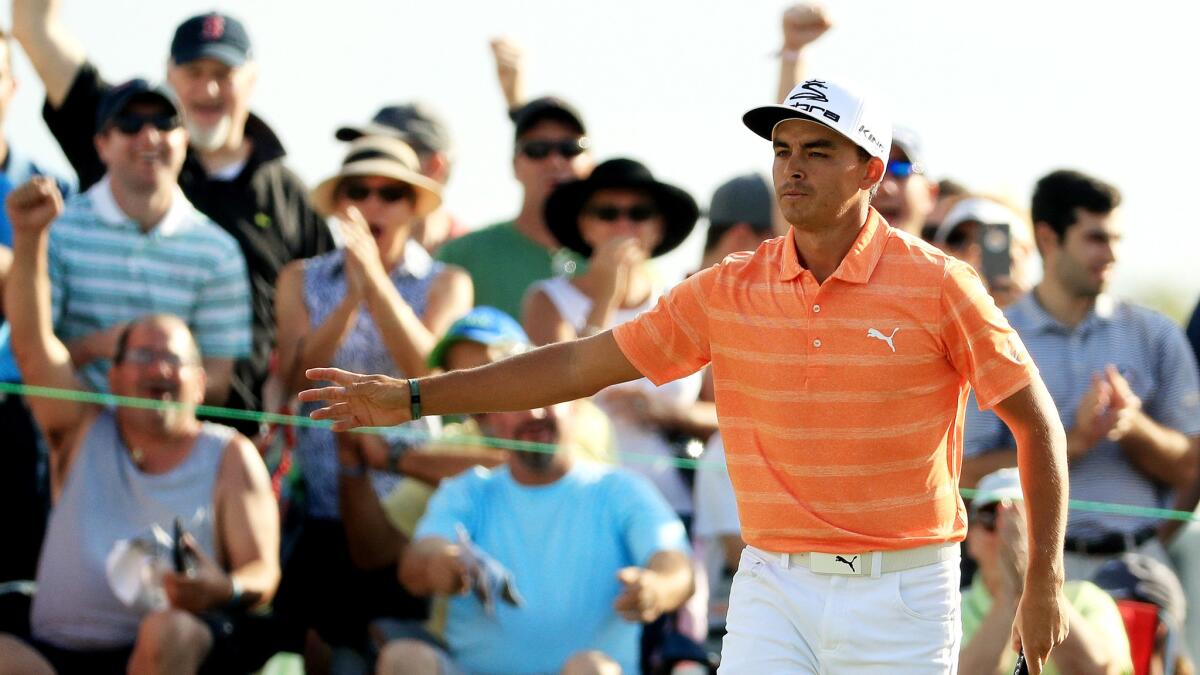 Rickie Fowler, as well as spectators, react to his birdie putt at No. 12 during the final round of the Honda Classic on Sunday.