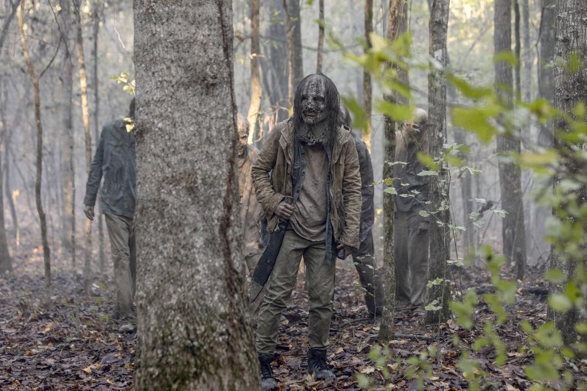 The Whisperers wander in the woods in "The Walking Dead."