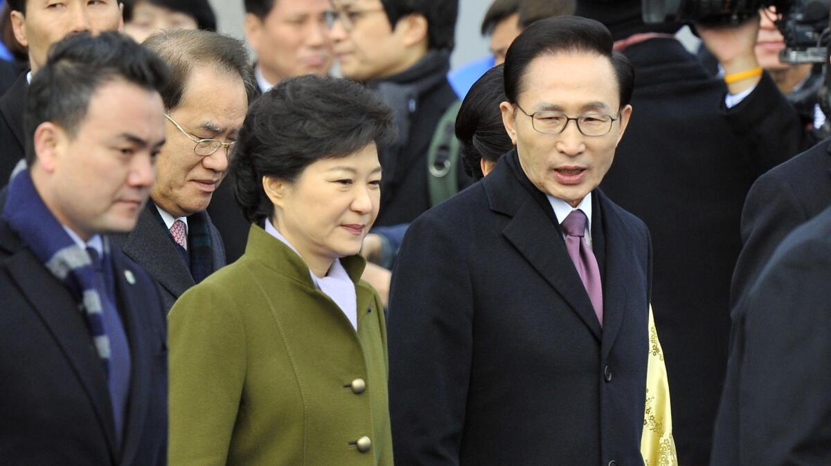 South Korea's Park Geun-hye walks with outgoing President Lee Myung-bak, right, during her presidential inauguration ceremony at the National Assembly in Seoul on Feb. 25, 2013.