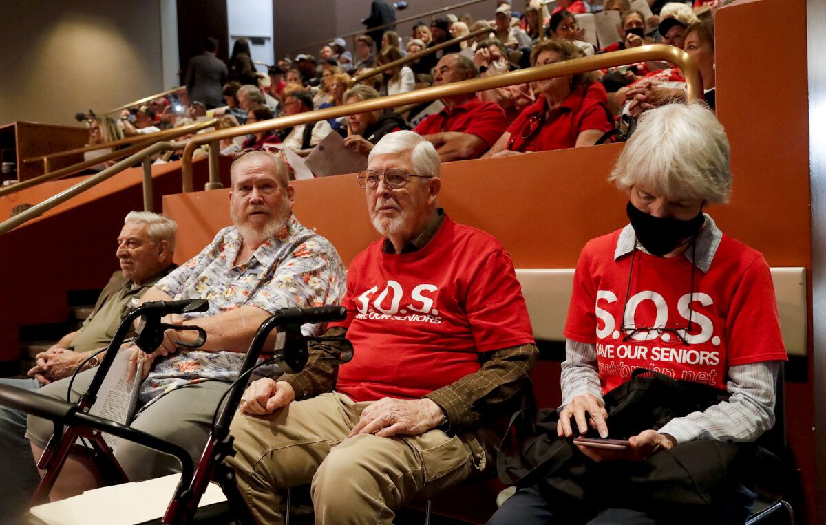 Bob Harold and Suzan Neil, in red shirts and residents of Skandia, wait to speak during a June City Council meeting.