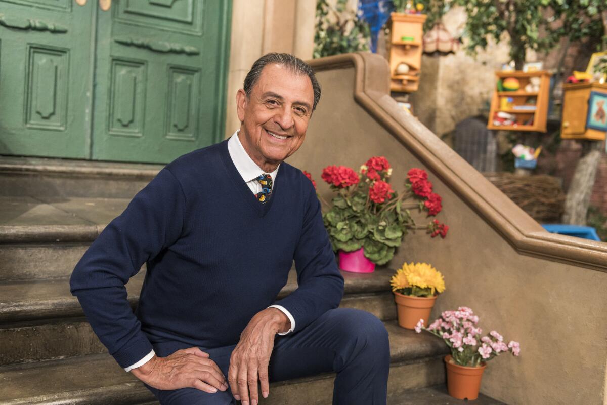 A man sitting on stairs next to potted flowers