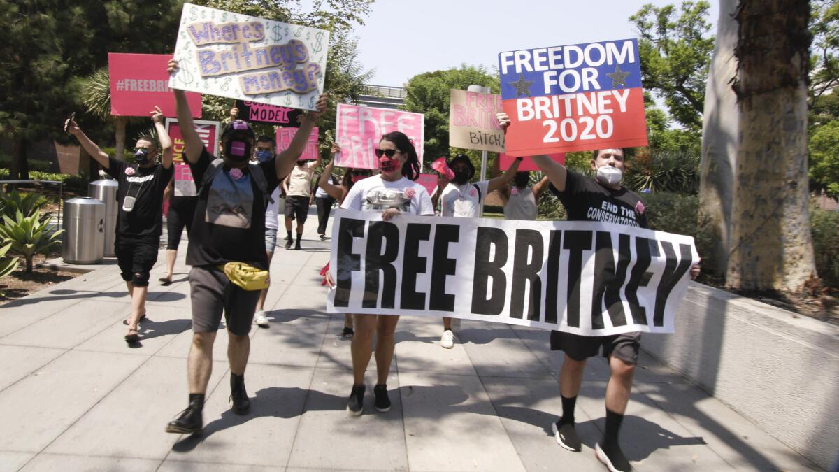 #FreeBritney activists hold signs and march near a Los Angeles courthouse.