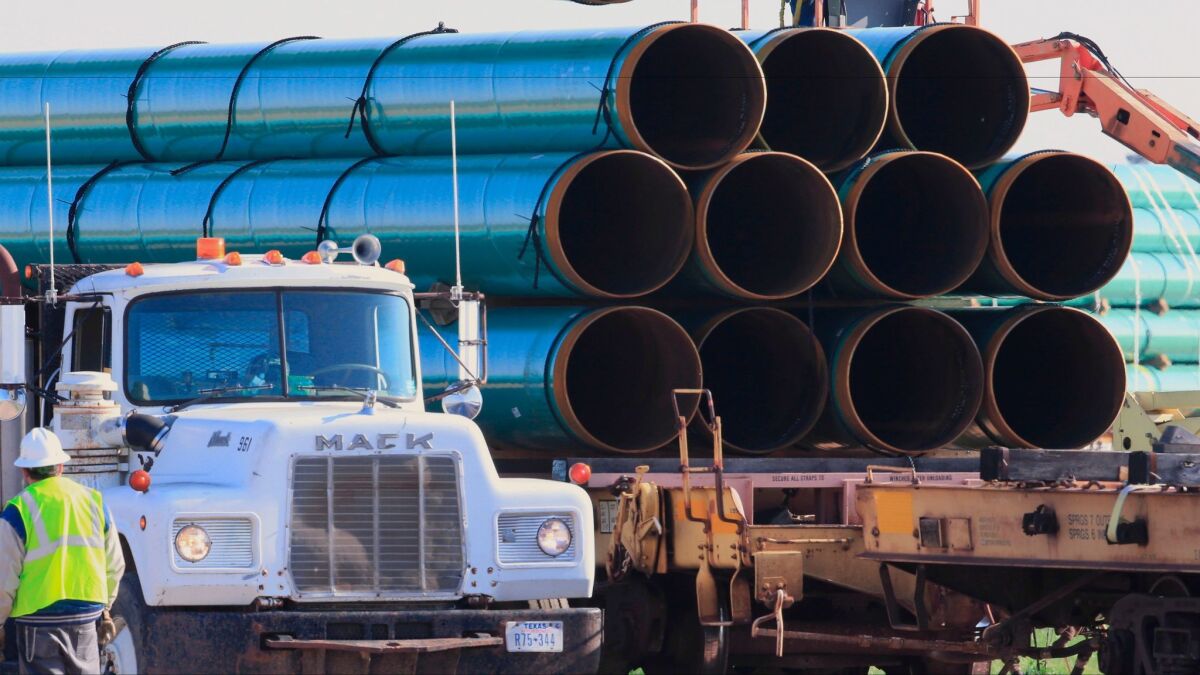 Workers in 2015 unload pipes for the Dakota Access oil pipeline.