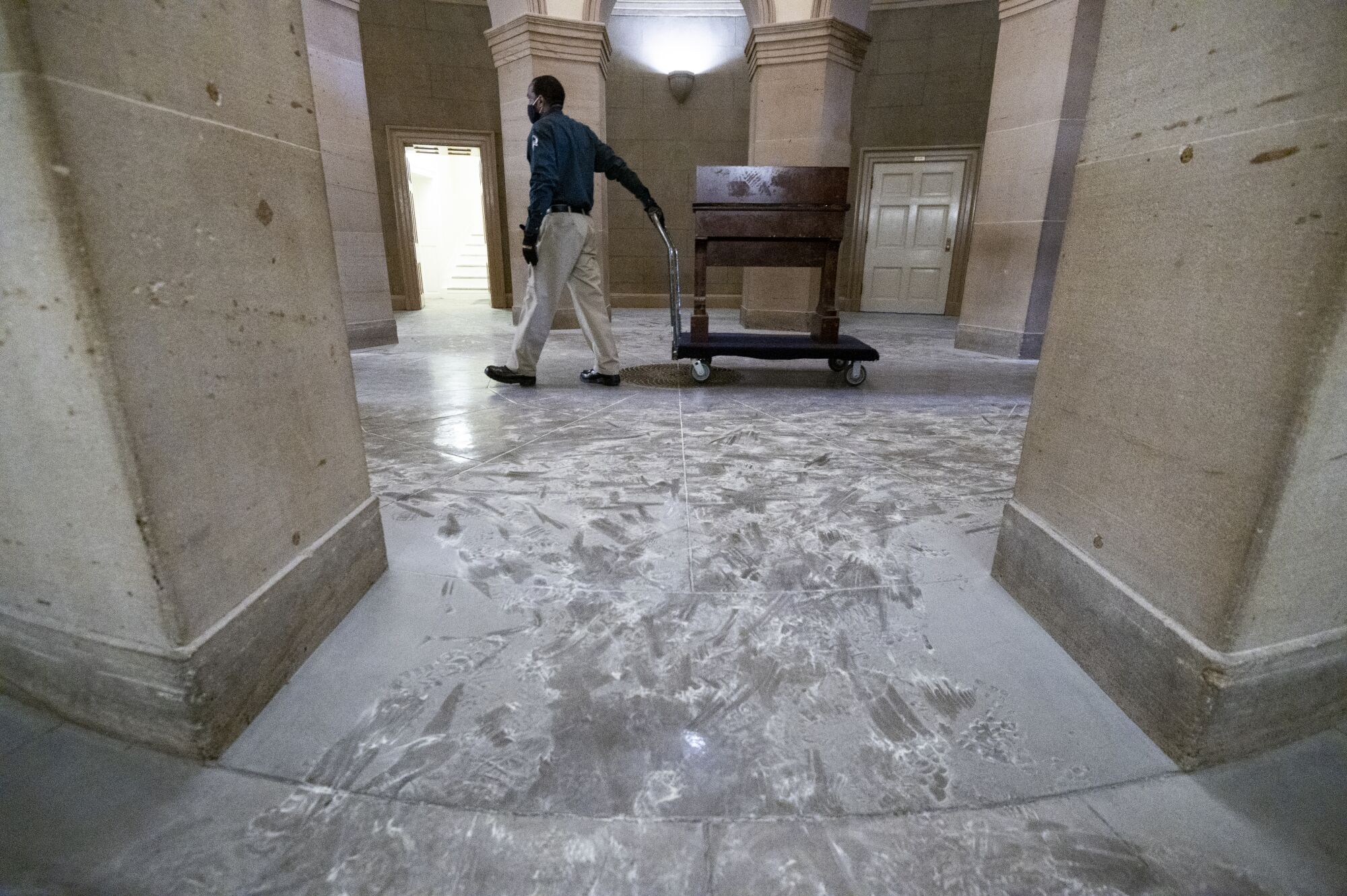 A Capitol worker removes damaged furniture on the Senate side of the building.