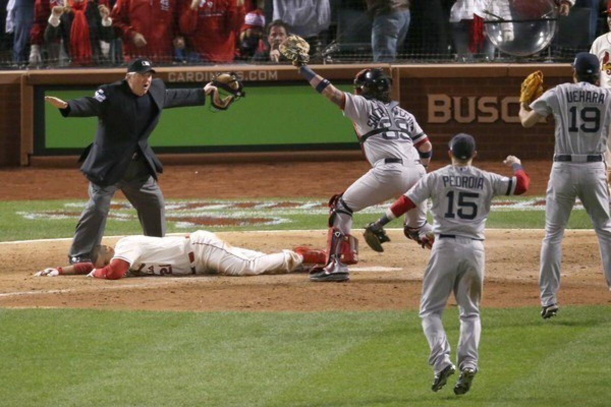 Home plate umpire Dana DeMuth, left, calls St. Louis' Allen Craig, center, safe at home against Boston catcher Jarrod Saltalamacchia in the bottom of the ninth inning to give the Cardinals a 5-4 win in Game 3 of the World Series.