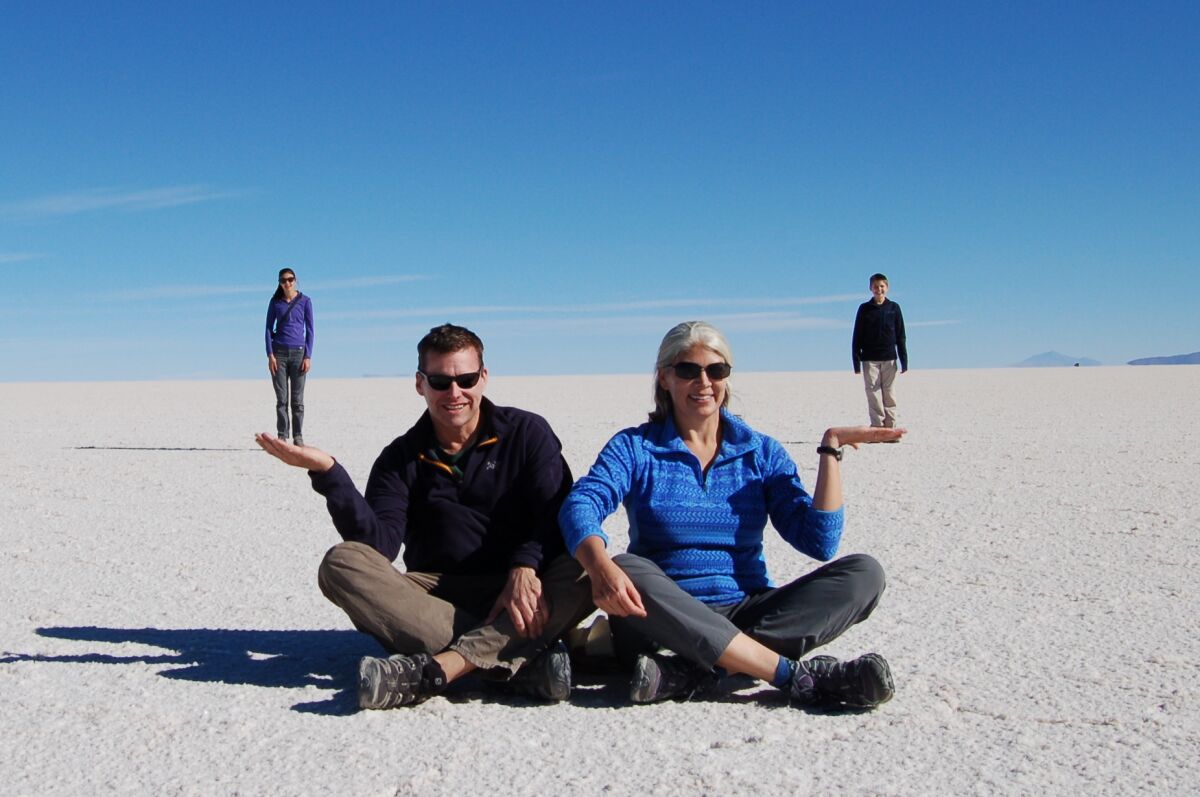 The Wheelans appear to hold their children in their outstretched palms in a trick photo taken on the Bolivian salt flats.