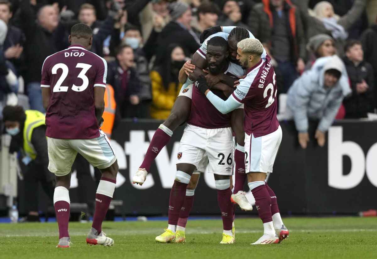 West Ham's Arthur Masuaku (26) celebrates after scoring his side's third goal during the English Premier League soccer match between West Ham United and Chelsea at the London stadium in London, Saturday, Dec. 4, 2021. (AP Photo/Alastair Grant)