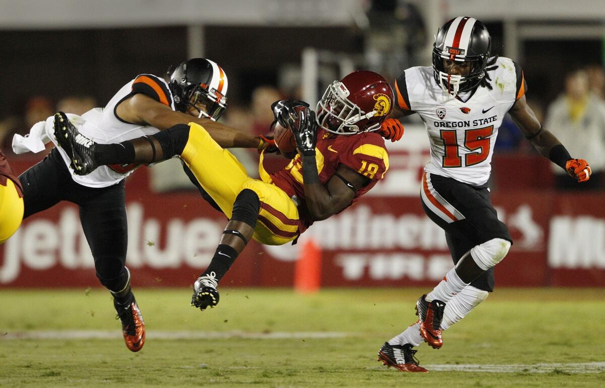 USC receiver Ajene Harris makes an acrobatic catch between Oregon State safety Tyrequek Zimmerman (8) and cornerback Larry Scott (15) in the second quarter.