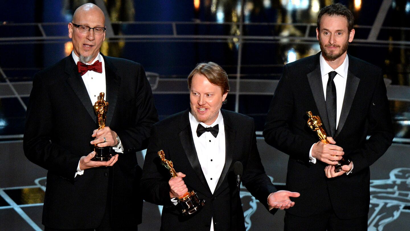 Winners for Best Animated Feature Film "Big Hero 6" Don Hall, center, Chris Williams, right, and Roy Conli accept their Oscars.
