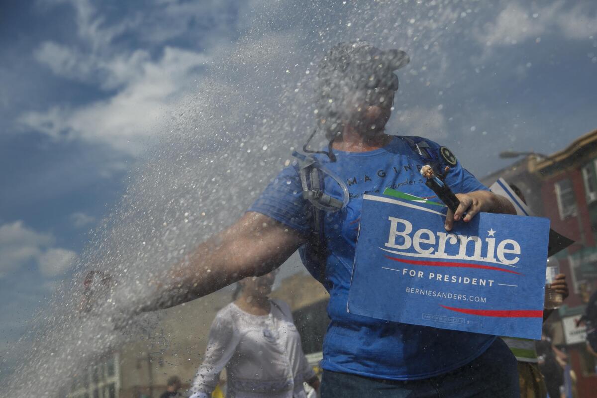 A Bernie Sanders supporter walks past an open fire hydrant in Philadelphia on Sunday.