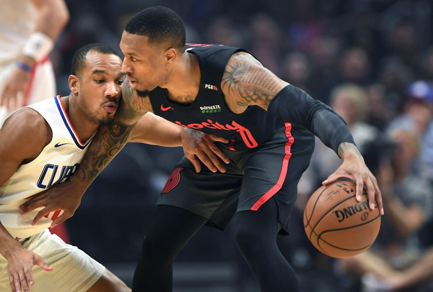 Clippers guard Avery Bradley defends Trailblazers guard Damian Lillard in the 1st quarter at the Staples Center on Monday.