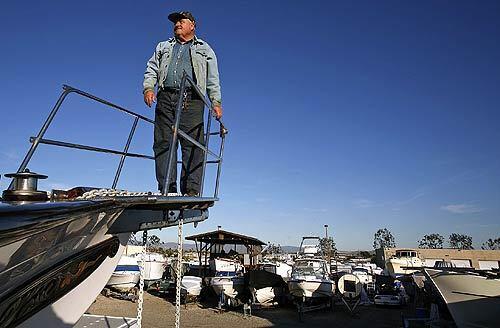 Karl Markvart stands on the bow of a friend's boat at the Boatyard Storage in Costa Mesa where the two men are building the home of their dreams. Markvart, 69, has been piecing his 32-foot Dreadnaught cutter together for more than three decades.