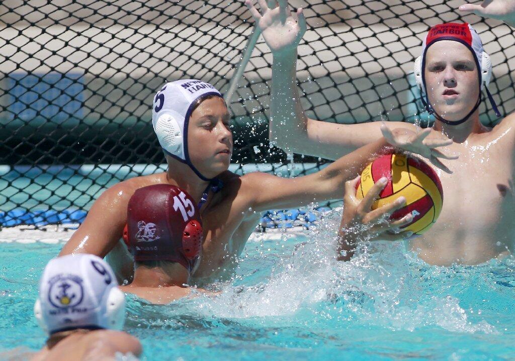 Newport Beach Water Polo's Jonathan Rimlinger (5) gets a field block on Trojan Water Polo Cardinal's Alex Wrightsman (15) during the first half in the USA Junior Olympics 14U boys' bronze match at the William Woollett Aquatic Center in Irvine on Tuesday.