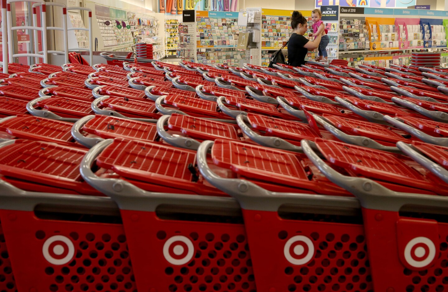 A woman places a child in a shopping cart at the remodeled Super Target store in Broadview on July 20, 2018.