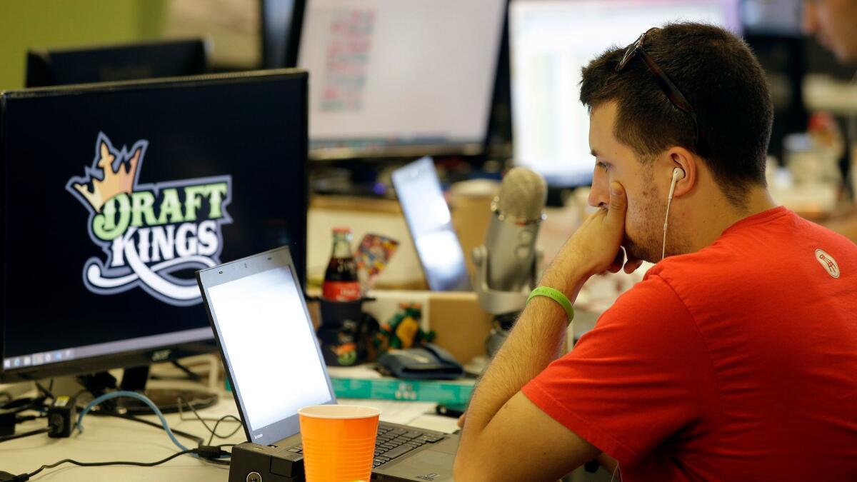 Devlin D'Zmura, a trending news manager at DraftKings, works on his laptop at the company's offices in Boston in 2015.