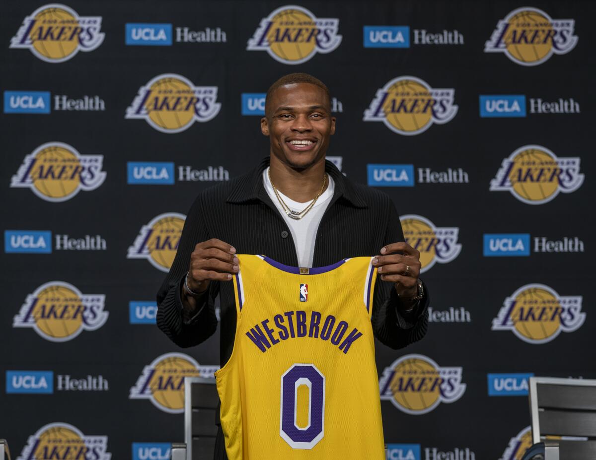 Russell Westbrook holds up his Lakers jersey after being introduced to the media as one of the newest Lakers.