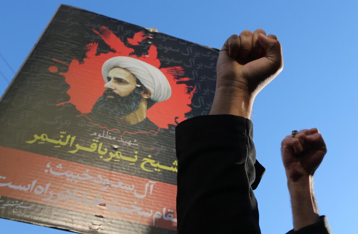 Protesters in the Iranian capital, Tehran, raise their fists in front of a poster of prominent Shiite Muslim cleric Nimr al-Nimr during a demonstration against his execution by Saudi Arabia in January. ( Atta Kenare/AFP/Getty Images)