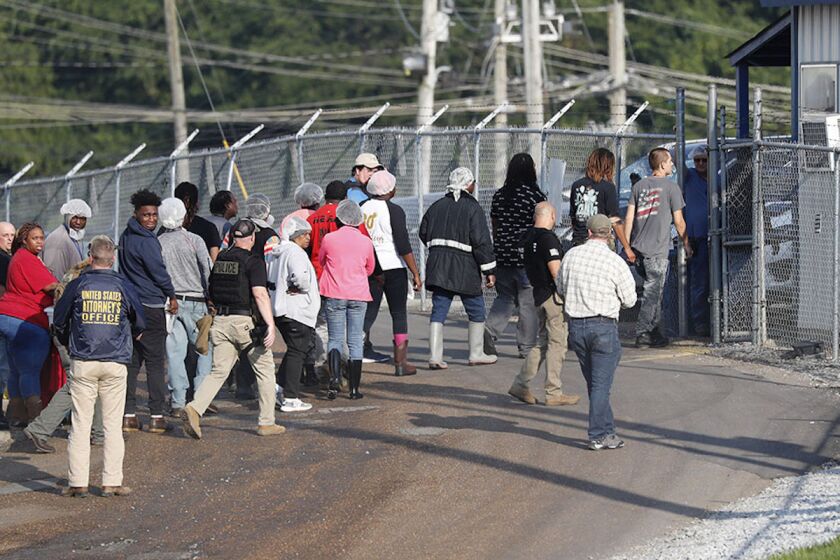 Empleados migrantes son detenidos por agentes migratorios en la planta Koch Foods Inc. en Morton, Mississippi.