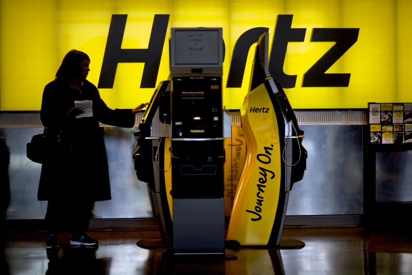 A customer checks in at a Hertz car rental counter at Hartsfield-Jackson Atlanta International Airport.