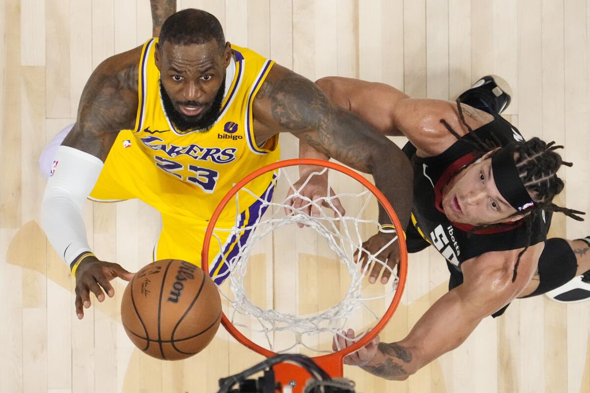 Lakers forward LeBron James, left, and Nuggets forward Aaron Gordon watch the ball bounce off the rim.