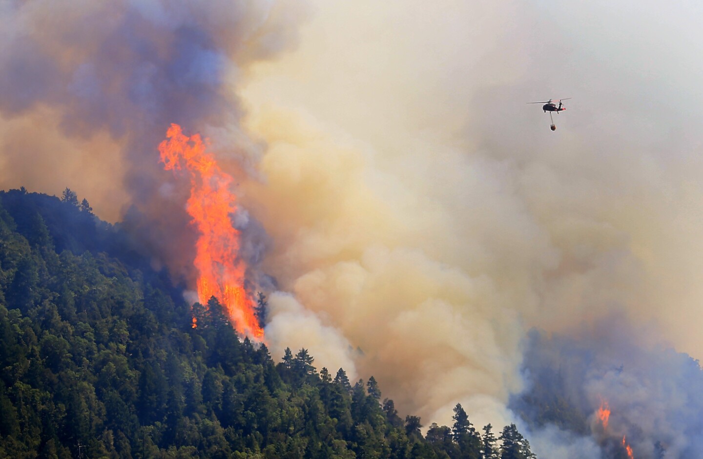 An Air National Guard helicopter moves in to make a water drop on the Lodge fire in Northern California. The fire was burning between Leggett and Laytonville in Mendocino County.