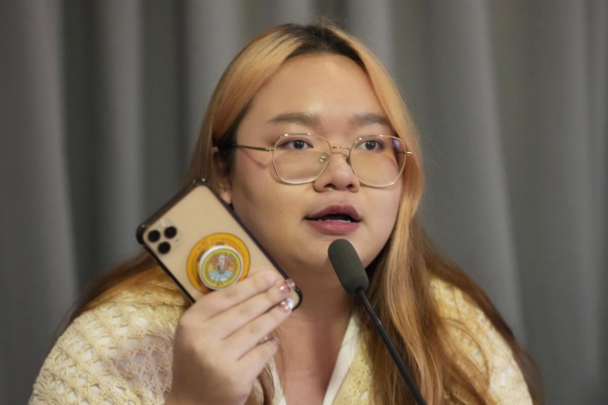 Thai democracy activist holding up her cellphone