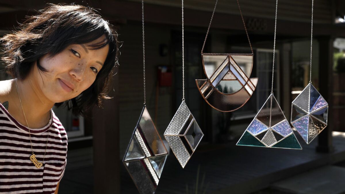 Stained glass artist Janel Foo is photographed with her stained glass sun catchers.