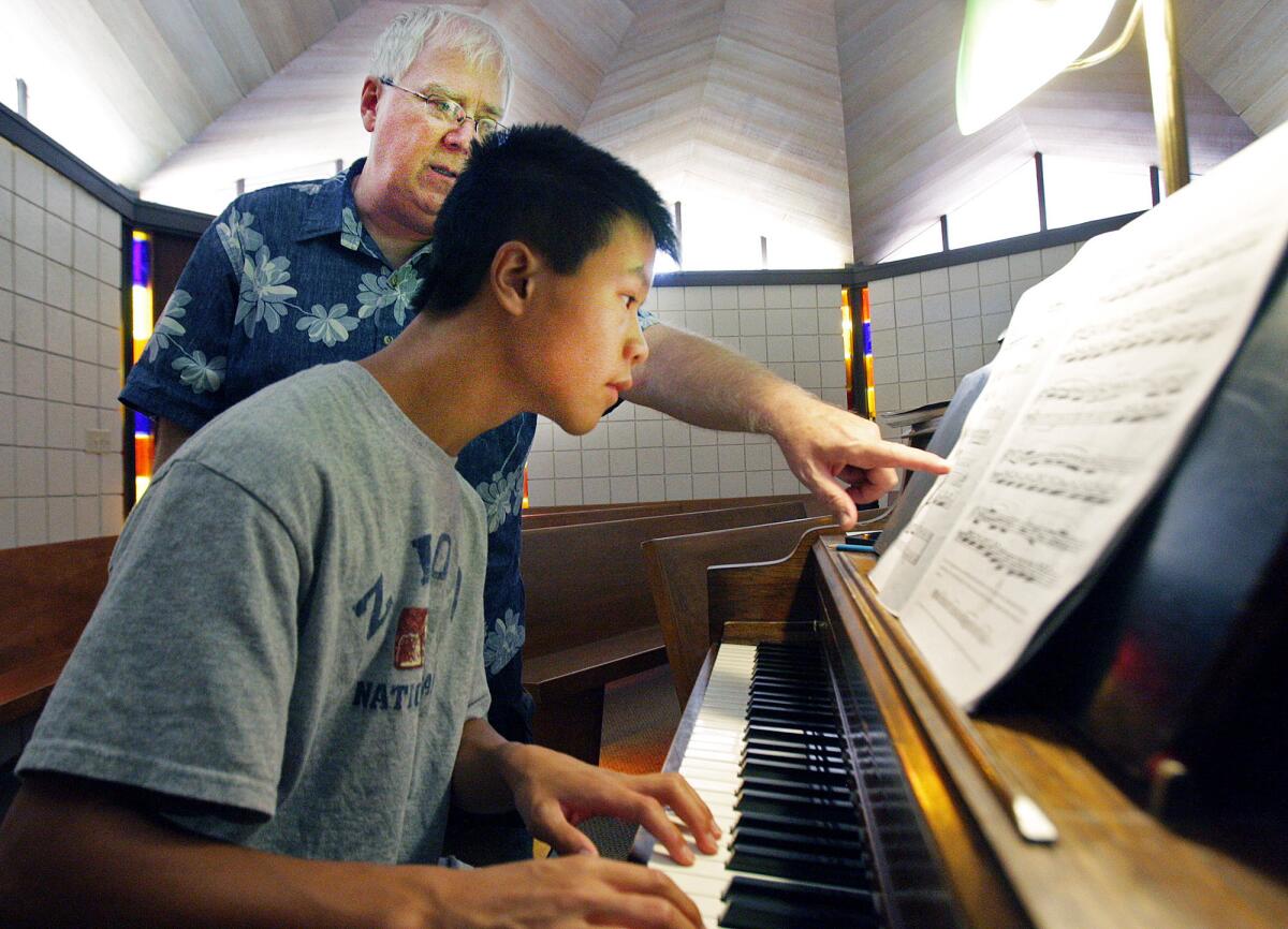 Jonathan Fong, 15, of Glendale, a four-year student of Charles Newschwanger, taking a lesson in the Samuelson Chapel at the Crescenta-Canada YMCA on Wednesday, August 13, 2014. Newschwanger has been teaching piano at the Y since 1998.