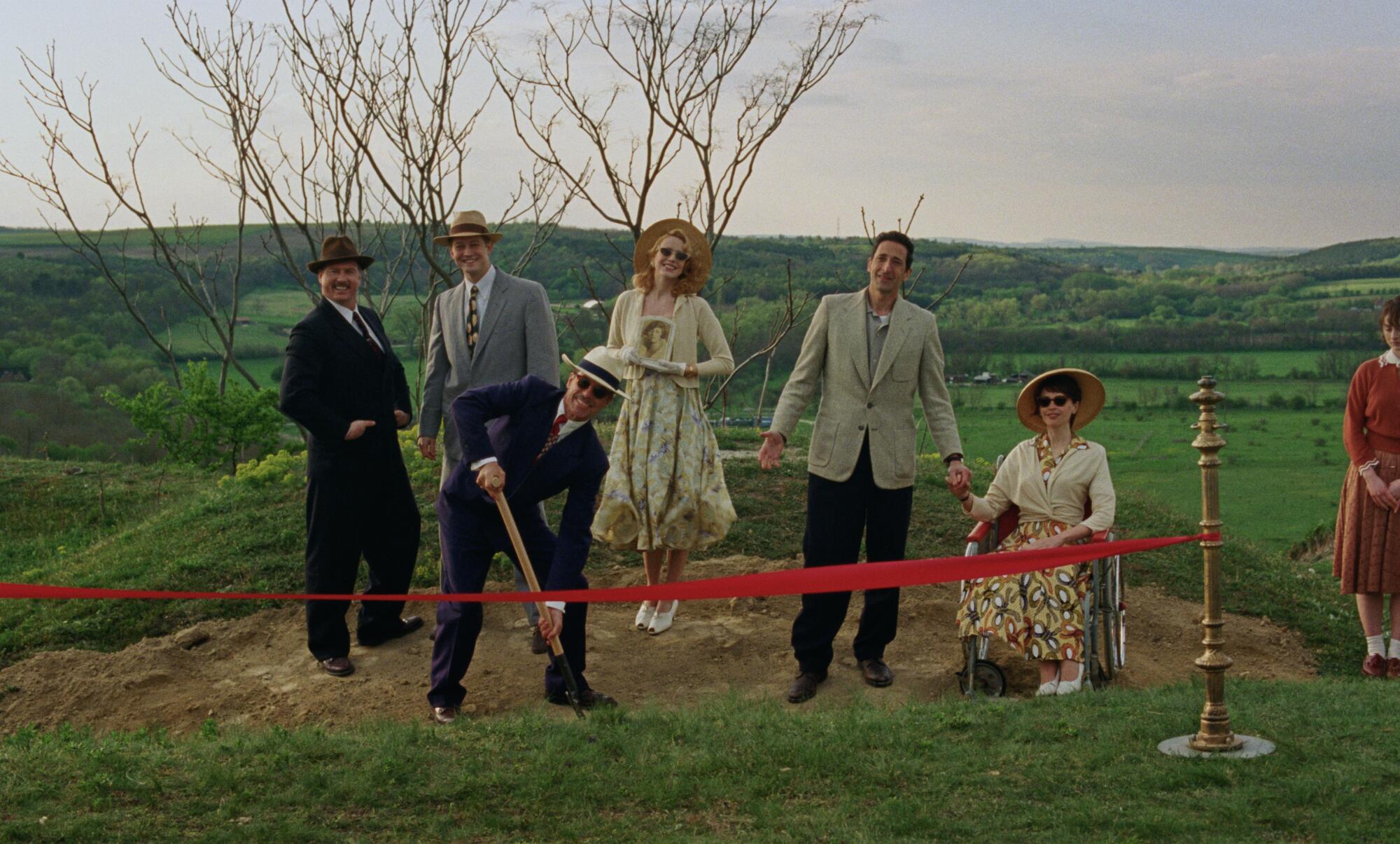 Several people celebrate the initial dig of a building's foundation.