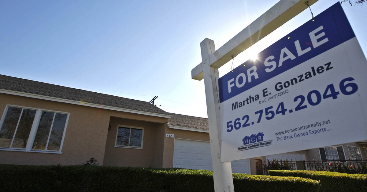 A for sale sign placed in front of a house in Compton.