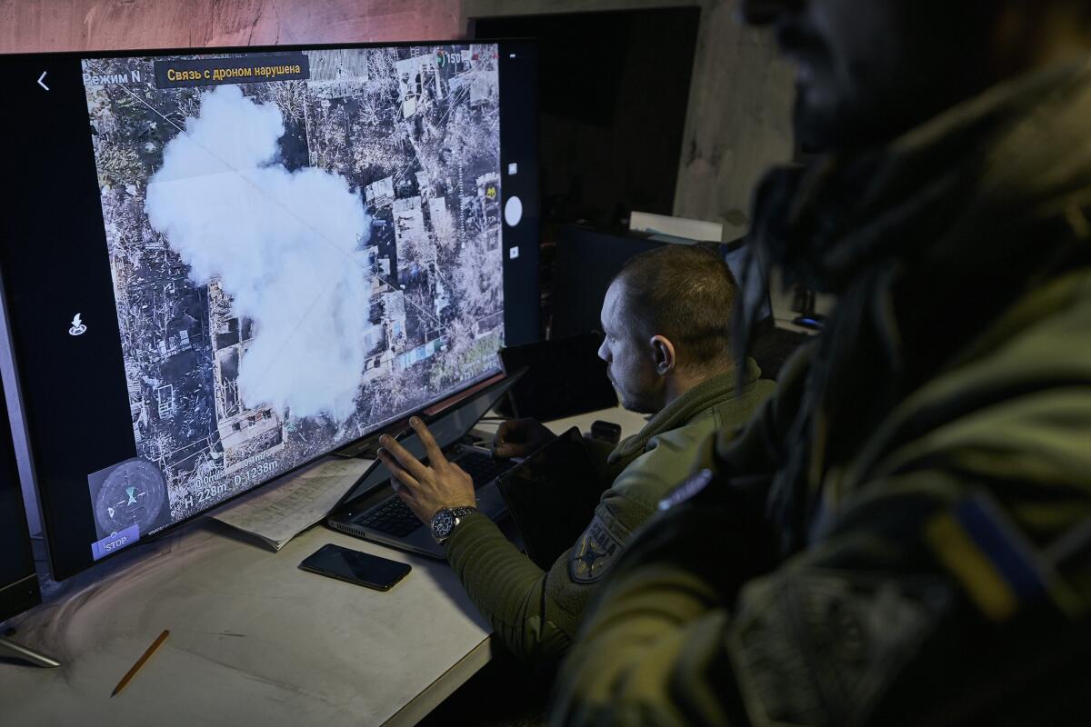 Soldiers watch a drone feed on a computer monitor.